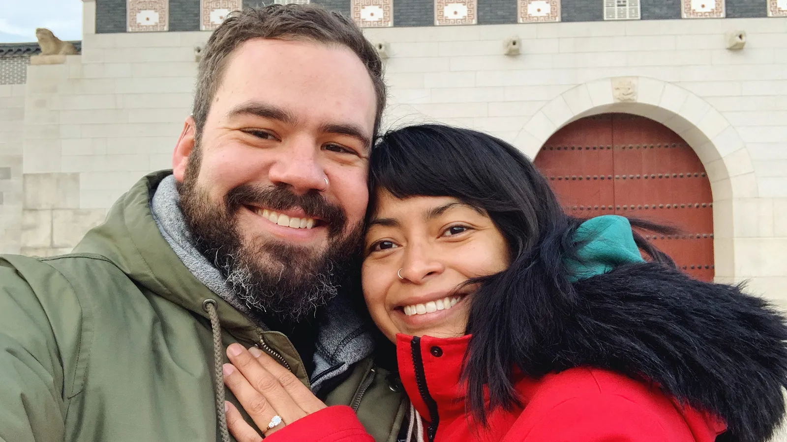 Consuelo resting her hand, and her new ring, on Peter&rsquo;s chest outside a palace gateway