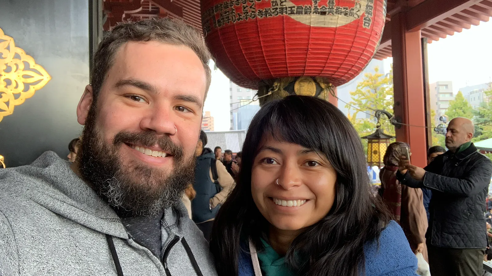 Peter and Consuelo beneath a huge red paper lantern at a temple gate