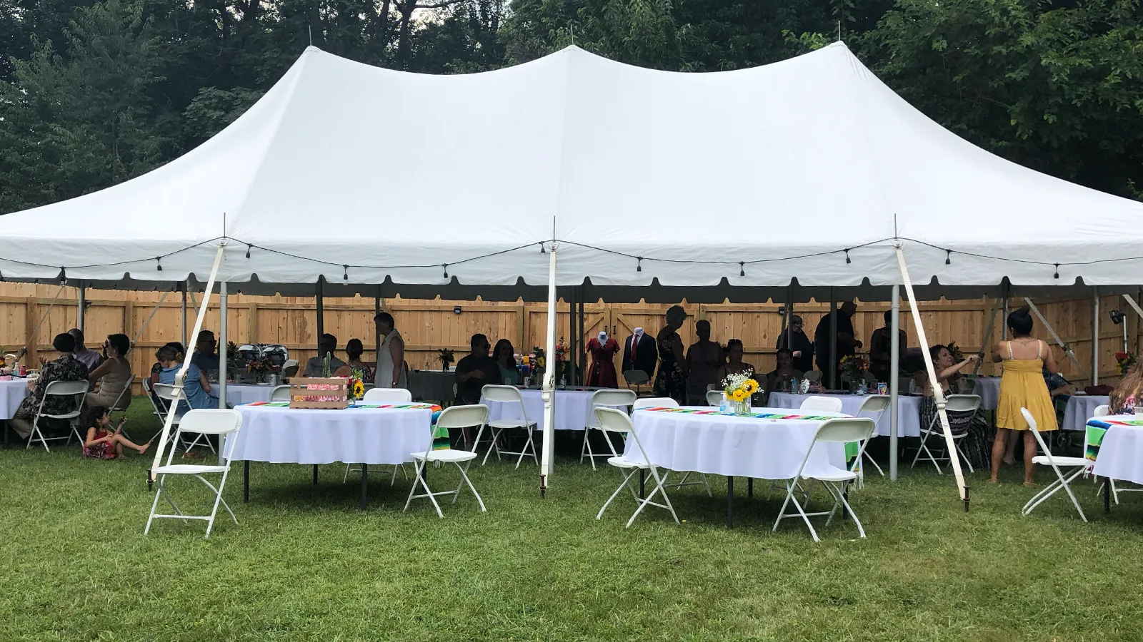 A white marquee set with tables and guests in the garden